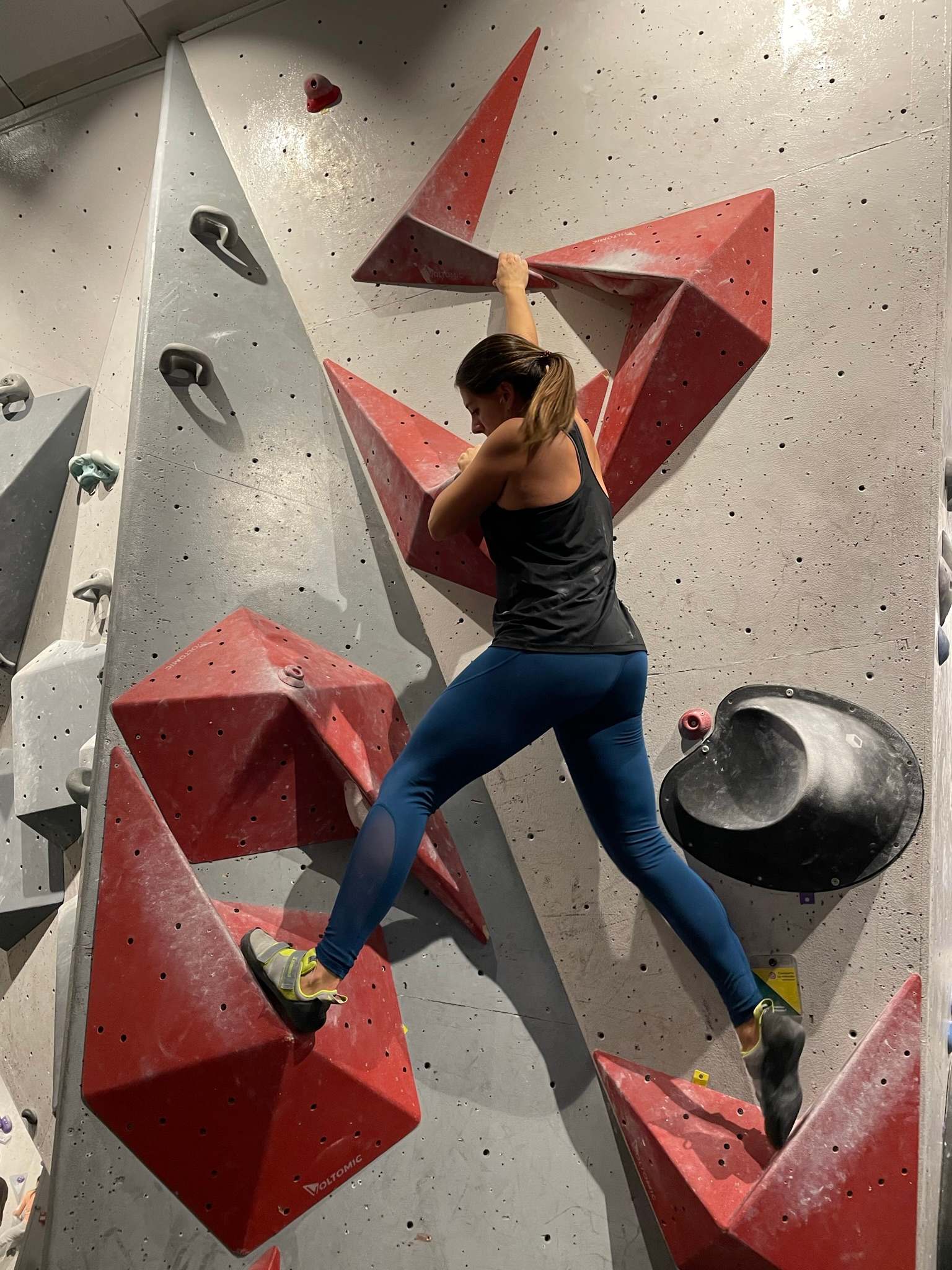 Fisioterapeuta de LSP escalando en bloque (búlder) en rocódromo